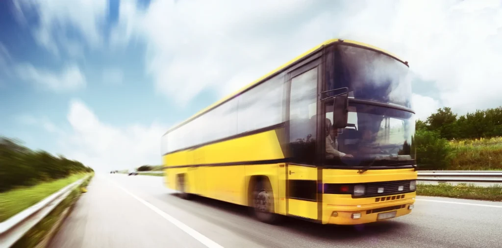 A yellow bus driving down the road, part of the NYCTA accountable bus accident. A yellow bus driving down the road, part of the NYCTA accountable bus accident.